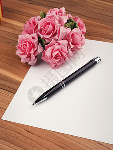 空白卡片与一支笔和粉红玫瑰背景图片