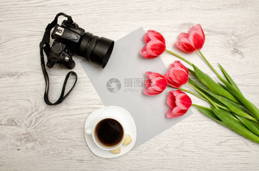 白纸咖啡和照相机浅木背景的粉红郁金香顶部视图图片