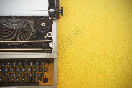 黄色背景上的老式打字机背景图片
