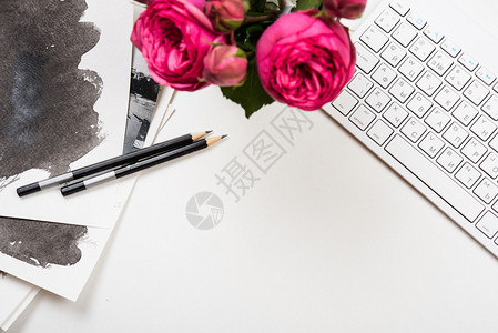 白桌上的风格式桌面模型计算机键盘和粉红色花朵图片