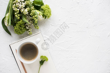 白纹桌面上花和衣物的女平板图片