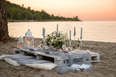 婚礼餐桌上的配饰特写在海滩上的婚礼餐桌上的配饰日落时婚礼图片