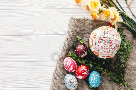 质朴的木制背景上的时尚彩蛋和复活节蛋糕图片