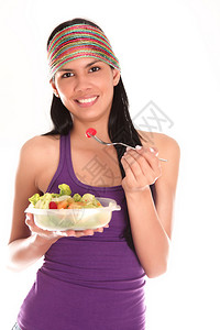 在白色背景下吃沙拉的年轻女子图片