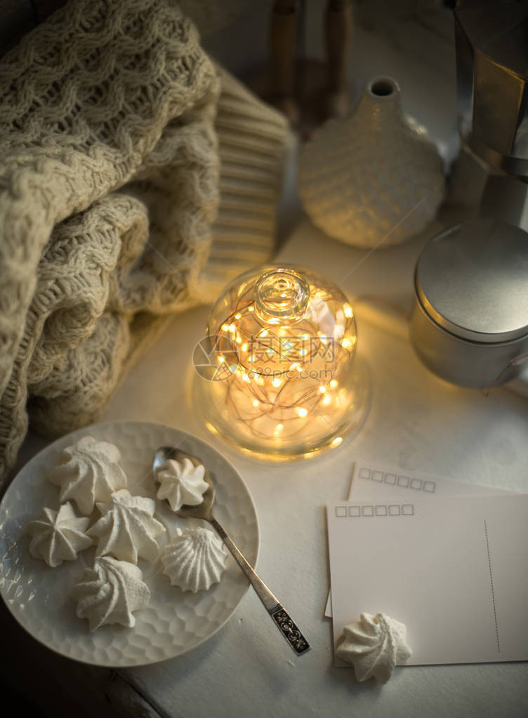 舒适的冬季室内风格和装饰钟罩内温暖的灯串室内自制糖果和针织图片