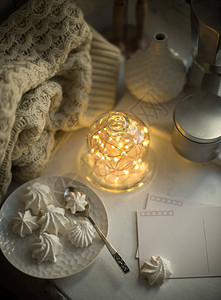 舒适的冬季室内风格和装饰钟罩内温暖的灯串室内自制糖果和针织图片