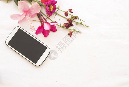 五颜六色的花束鲜花与手机在背景白色背景图片