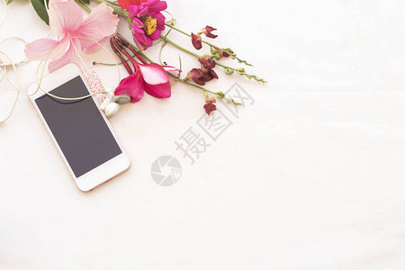 五颜六色的花束鲜花与手机在背景白色图片