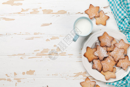白色木制桌上的饼干和含牛奶的蓝图片