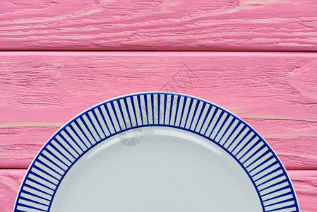 粉红色木桌上空圆盘的顶视图图片
