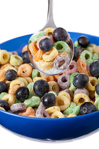 在白色背景的蓝色碗里放着蓝莓和的五颜六色的麦片图片