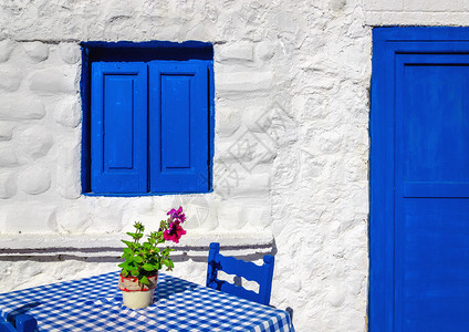 希腊住房前带有木椅和窗子的蓝色图片