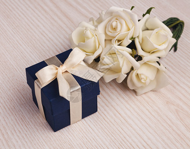白玫瑰和蓝色礼品盒木制图片