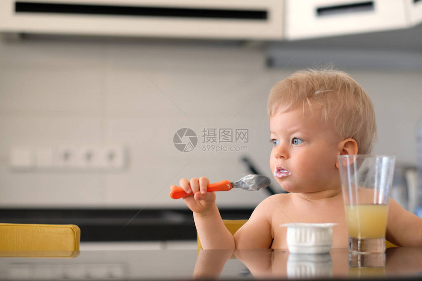 可爱的一岁小男孩用勺子吃酸奶幼稚孩图片