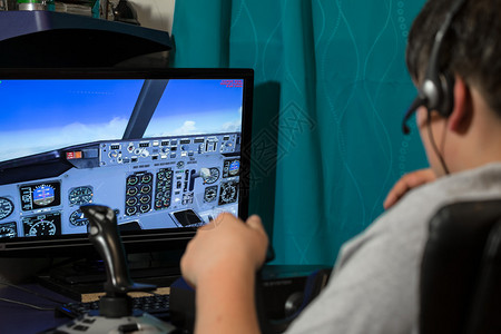 具有飞行模拟器任务的电脑屏幕前人员图片
