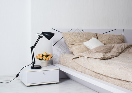 里面有明亮的白色卧室舒适的床铺和米色麻布床边图片