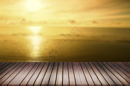 以模糊明亮的海水和日落背景为顶层的木板图片