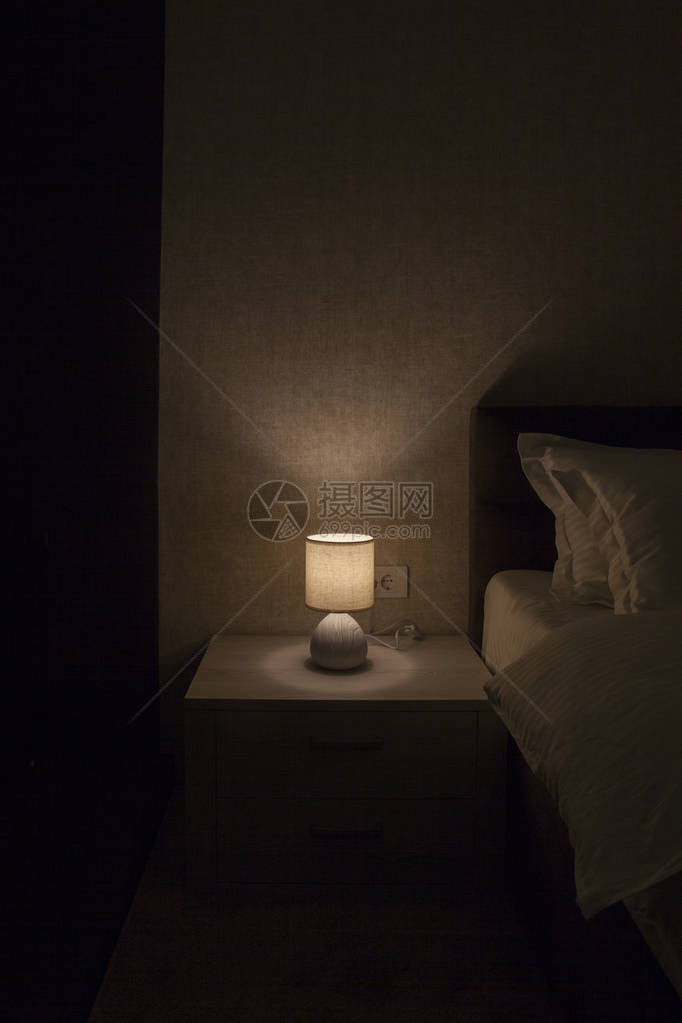黑暗中床头柜上的灯图片