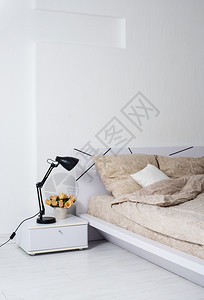 里面有明亮的白色卧室内衣舒适的床铺和米色麻布床边图片