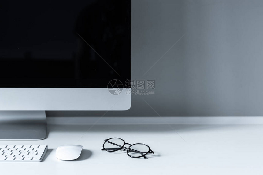 工作台上带键盘的眼镜和电脑鼠标图片