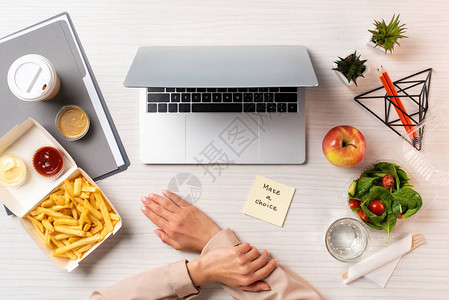 商业女商人膝上型电脑记录笔记本在工作场所做出选择和健康食品及垃图片