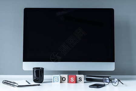电脑和木制立方体桌上有Boss字样图片