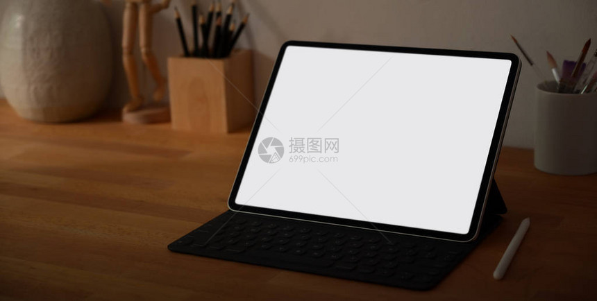 用空白屏幕数字平板电脑和木制桌上办公用品对设计师工作场所的近视图片图片