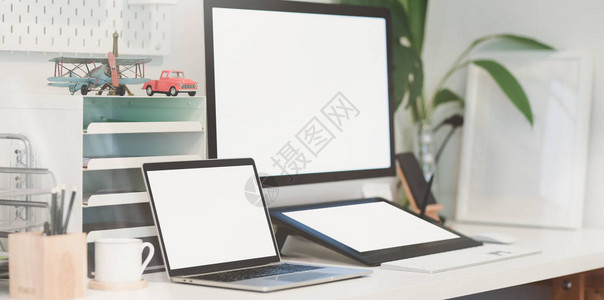 现代工作场所的空白屏幕台式计算机和平板电脑图片