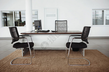 现代办公室内部一张桌子两把椅子和一图片