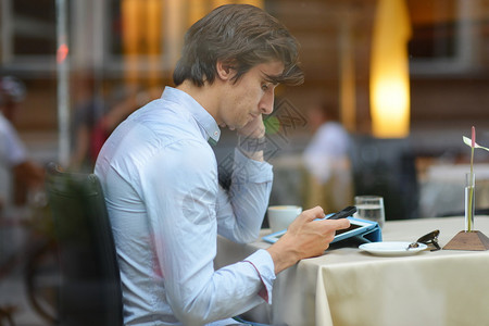 年轻时尚男潮人在午餐时间在城市咖啡馆喝浓缩咖啡图片