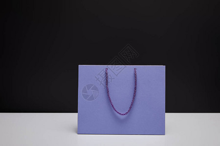 白色桌子上一个紫色购物袋背景图片
