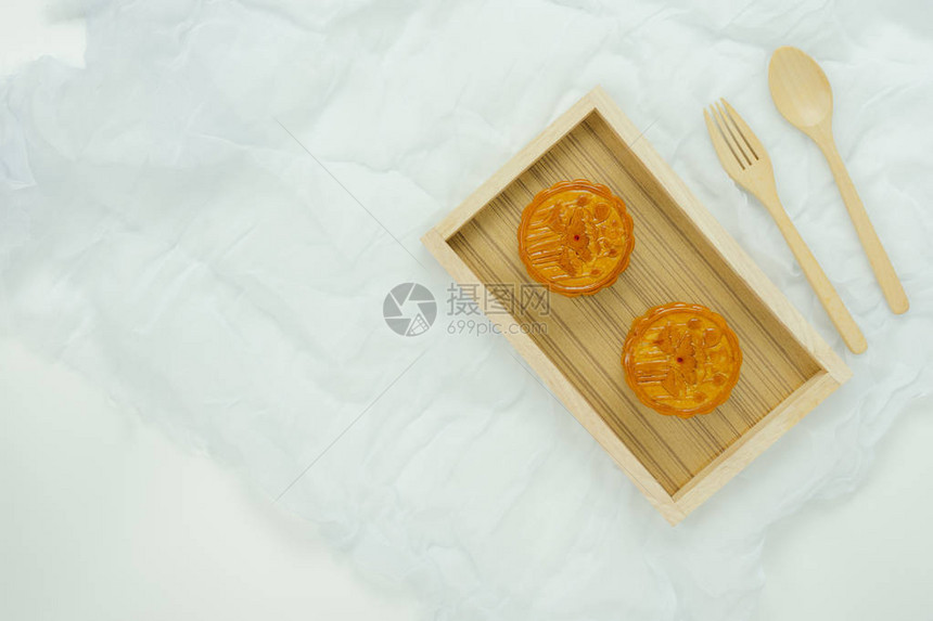 桌面视图装饰秋节或农历背景概念的空中图像平躺甜月饼和木勺和叉子与白色木制的衣图片