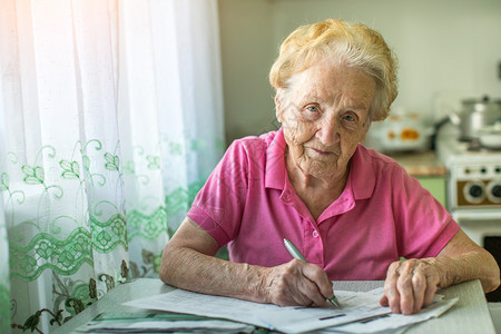 老年妇女支付公用服务费的账单由图片