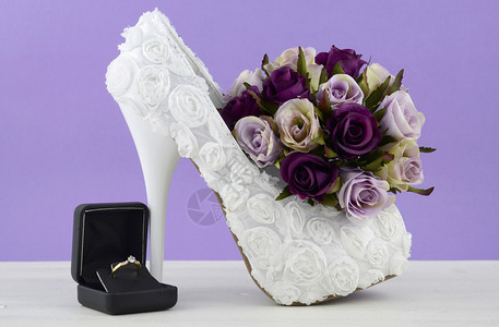 婚礼主题白花新娘鞋花朵在破旧的黑白桌背景图片