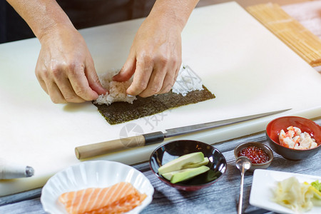 手摸白米菜叶旁的刀子草木卷的基本原料图片