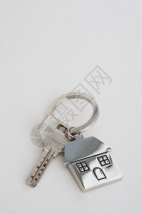 新房主抵押钥匙和钥匙圈放在一张白色的桌子上图片