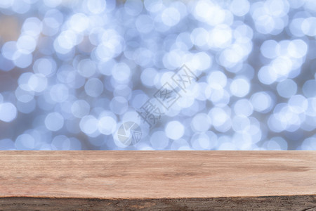 白色明亮散景灯前的木桌背景图片