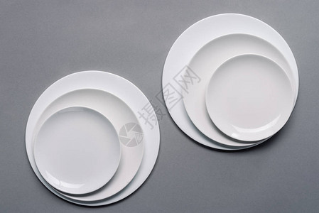 灰色背景上闪亮的白色厨房陶瓷盘图片