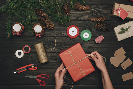 装饰圣诞礼物和木制桌子上线的女图片