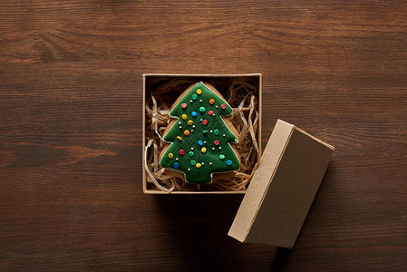 圣诞树饼干在木制桌上的礼物盒图片