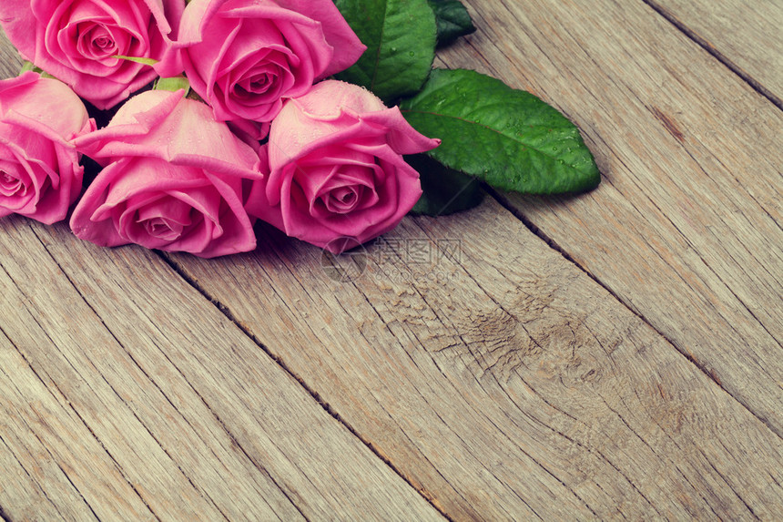 粉红玫瑰花束在木制桌边图片