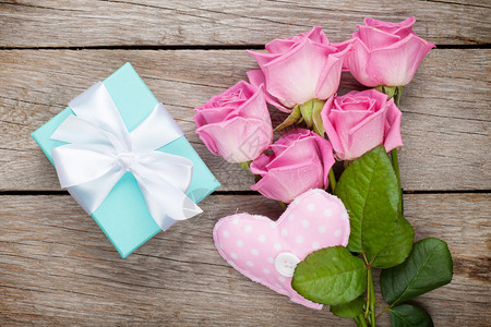 礼品盒粉红玫瑰花束和手工制作的心脏玩具在图片