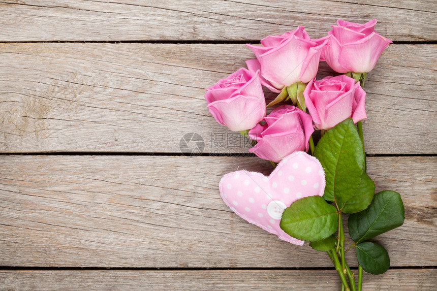 粉红玫瑰花束和手工制作的心脏玩具在图片