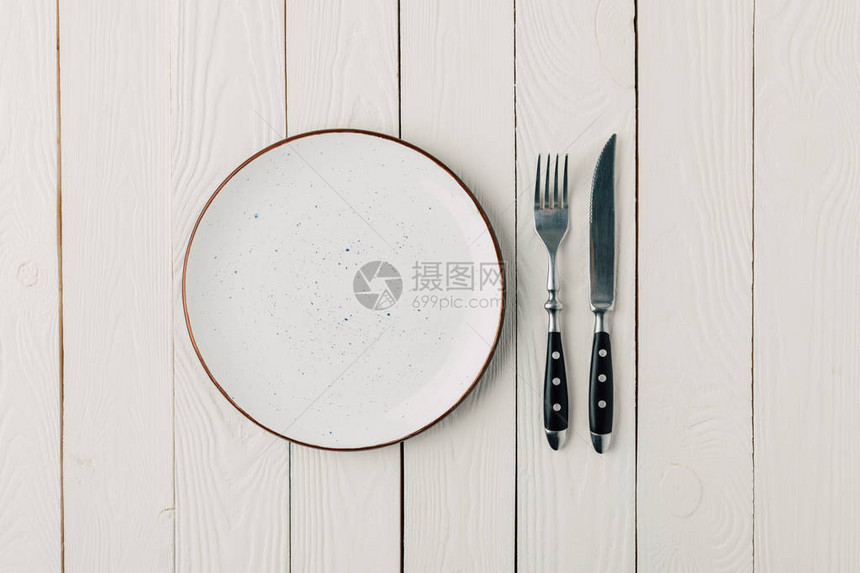 白色木质背景上的空盘子和餐具图片