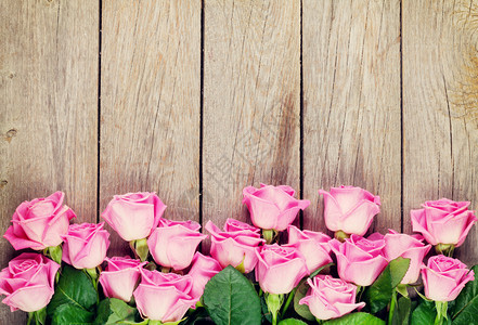 粉红玫瑰花束在木制桌子上方背景图片