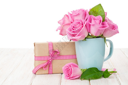 情人节粉红玫瑰花束和白色木桌上的礼盒图片