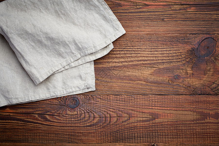 棕色木桌上的亚麻餐巾图片