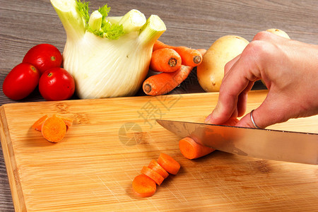 用手和刀在桌子上的蔬菜图片