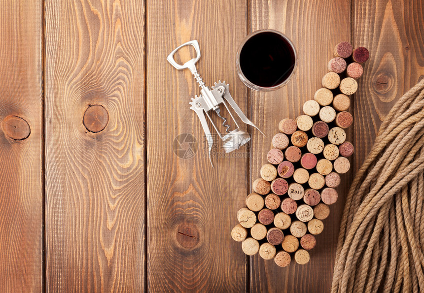 葡萄酒瓶装软木箱红酒杯和在生锈木制桌布背图片
