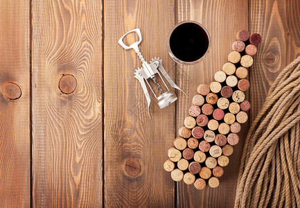 葡萄酒瓶装软木箱红酒杯和在生锈木制桌布背图片